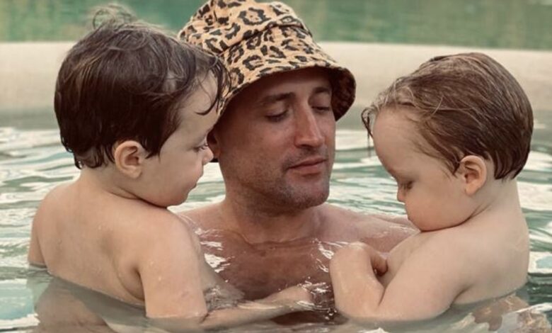 Paulo Gustavo segurando os dois filhos na piscina